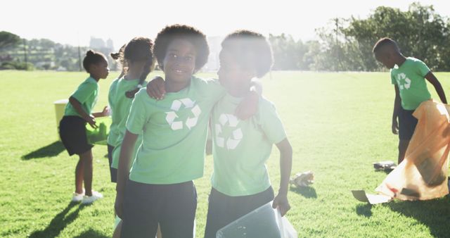 Happy diverse school children wearing green t-shirts with recycling symbol. Education, learning, ecology, environment, inclusivity and school, unaltered.