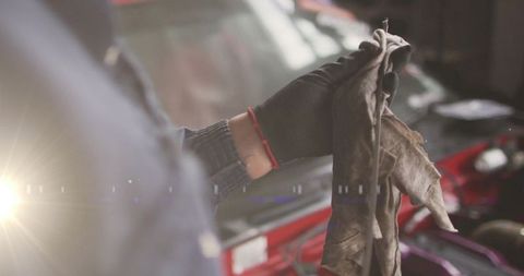 Mechanic Cleaning Vehicle Engine with Rag in Repair Workshop