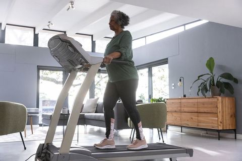 Senior Woman Exercising on Treadmill in Modern Living Room
