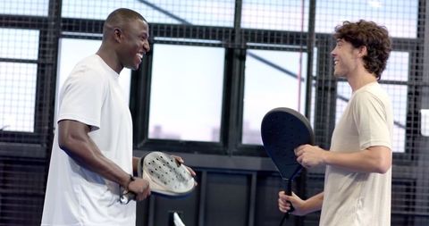 Two Friends Enjoy Energetic Padel Match in Sports Center