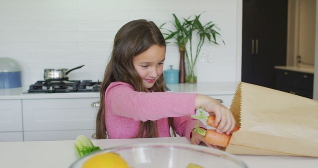 Smiling Girl Packing Fresh Vegetables in Kitchen - Download Free Stock Images Pikwizard.com