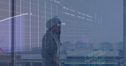 Businesswoman Analyzing Financial Graphs on Computer Screen in Modern Office