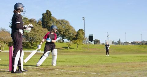 Female Cricketers Competing in a Park Match