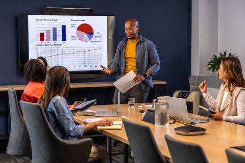 Business team presenting quarterly growth charts in modern conference room for data collaboration