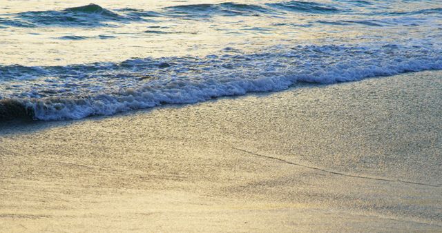 Gentle waves wash onto a sandy beach during a tranquil sunset, with copy space - Download Free Stock Photos Pikwizard.com