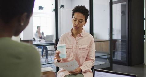 Diverse Businesswomen Collaborating Over Coffee in Modern Office