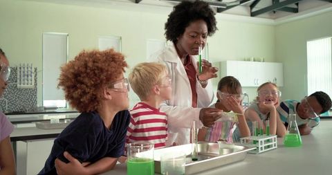 Black teacher demonstrating hands-on chemistry experiment to diverse elementary students
