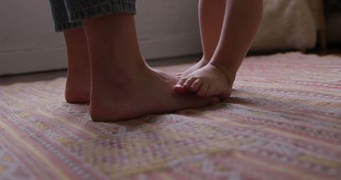 Tender moment: adult and child feet on patterned rug