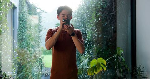 Man Sipping Coffee in Botanical Glass Sunroom