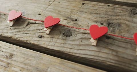 Red paper hearts garlands on rustic wooden planks