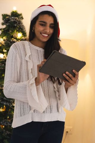 Smiling Asian Woman with Tablet Celebrating Christmas at Home