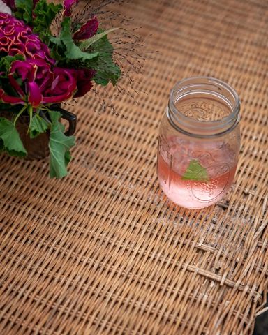 Refreshing pink mocktail in mason jar on wicker table