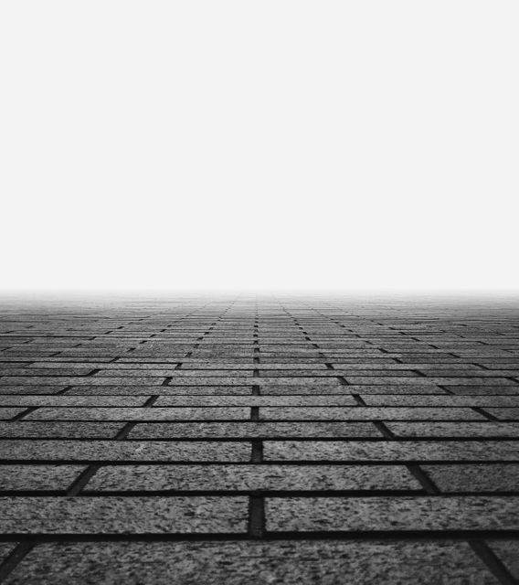 Brick path creating illusion of endless perspective, showcasing vanishing point effect. Great for architecture designs, graphic arts, surreal illustrations, backgrounds, and urban concepts.
