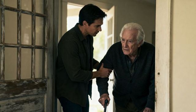 Adult caregiver assisting elderly man entering home using cane supporting mobility and dignity