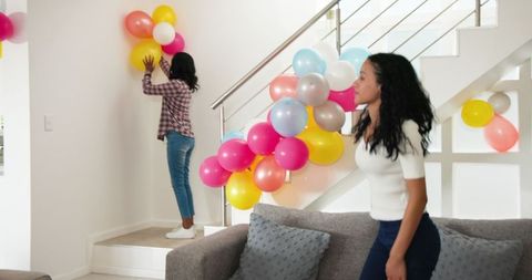 African American Family Decorating Home with Colorful Balloons