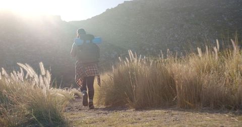 Woman Hiking on Mountain Trail with Backpack and Yoga Mat