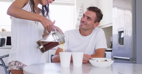 Caucasian Couple Sharing Breakfast Moment in Sunlit Kitchen
