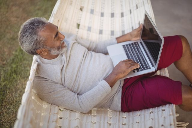 Senior Man Relaxing on Hammock Using Laptop - Download Free Stock Images Pikwizard.com