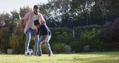 Father and Son Bonding Over Soccer in Backyard on Sunny Day