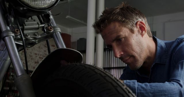 Focused Mechanic Repairing Motorcycle Tire in Workshop - Download Free Stock Images Pikwizard.com