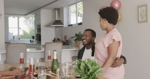 Joyful Friends Gathering for Meal and Laughter in Modern Kitchen