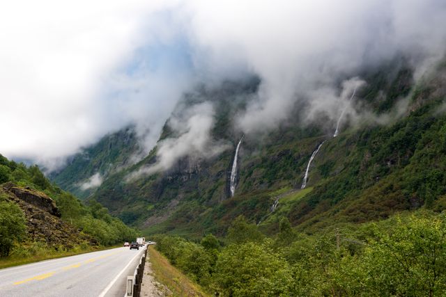 Foggy Mountain Road with Waterfalls and Lush Greenery - Download Free Stock Photos Pikwizard.com