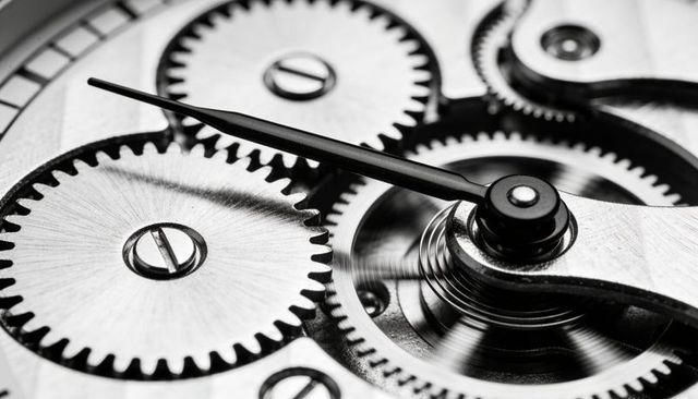 Macro monochrome close-up of mechanical watch movement showing gears, hairspring, balance wheel
