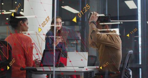 Team testing VR headset during immersive collaboration in modern glass conference room