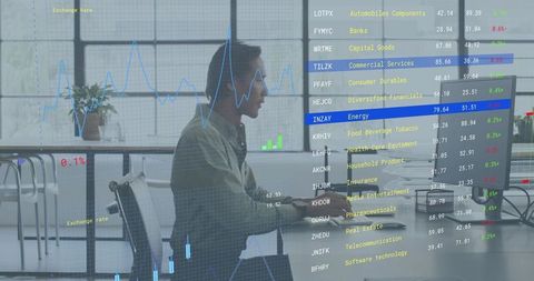 Mid-adult man monitoring stock analytics on desktop with financial dashboards overlaying