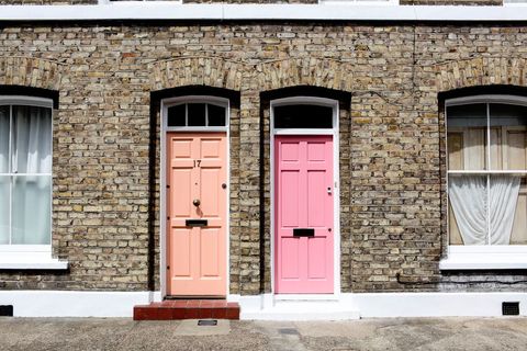Charming vintage brick facade featuring adjacent peach and pink front doors number 17