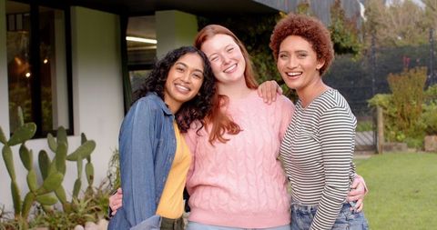 Diverse Female Friends Smiling Outdoors in Modern Home Garden