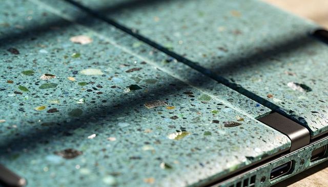 Turquoise terrazzo laptop lid resting under slatted sunlight, speckled hinge detail
