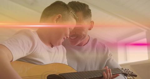 Father Teaching Son to Play Guitar, Sharing Joyful Bonding Moment