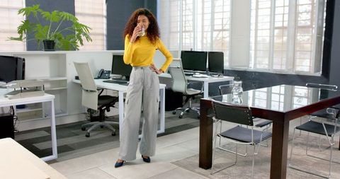 Businesswoman Taking Break Drinking Water in Modern Office