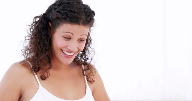 Smiling Woman with Curly Hair Looking Down in Excitement - Download Free Stock Images Pikwizard.com