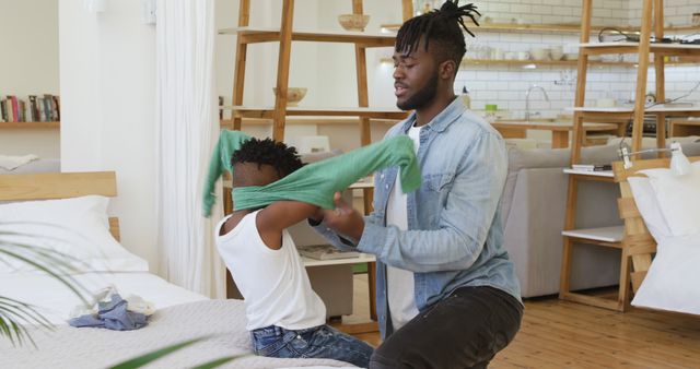 Father helping son get dressed in modern home - Download Free Stock Images Pikwizard.com