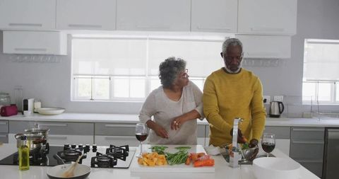 Senior Couple Cooking Together in Modern Kitchen with Wine and Fresh Ingredients