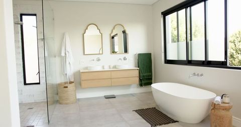 Modern Minimalist Bathroom with Freestanding Tub and Black Frame Window