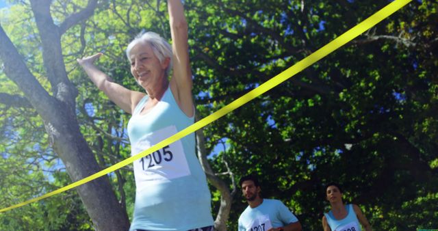 A senior Caucasian woman triumphantly crosses the finish line at a race, with copy space - Download Free Stock Photos Pikwizard.com
