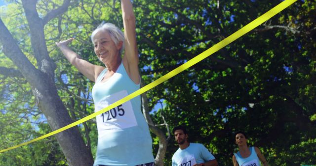 Senior woman crossing finish line at marathon, smiling runners behind her - Download Free Stock Images Pikwizard.com