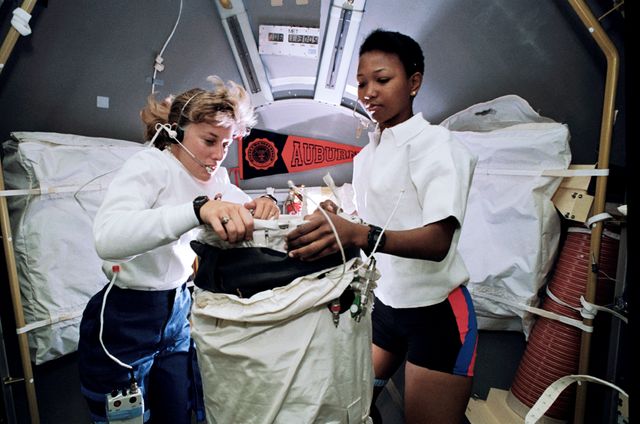 This image captures female astronauts N. Jan Davis and Mae C. Jemison working together inside Space Shuttle Endeavour during mission STS-47 in September 1992. Ideal for use in articles about women in STEM, space exploration history, NASA missions, and international space collaborations. Highlights teamwork and scientific research in outer space.