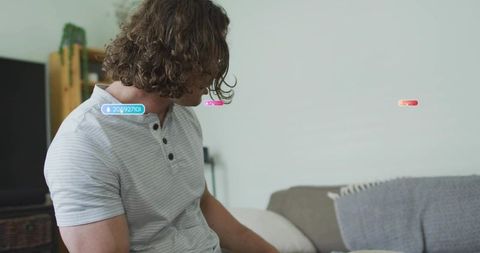 Middle-aged man sitting casually on gray sofa in cozy living room
