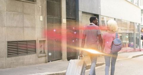 Couple Walking City Street with Suitcase and Backpack