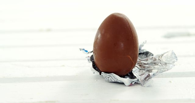 Chocolate Egg Partially Unwrapped with Aluminum Foil on White Surface - Download Free Stock Images Pikwizard.com