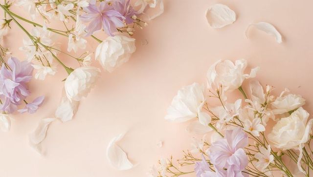 Soft pastel floral flatlay with white ranunculus and lavender blooms on peach backdrop