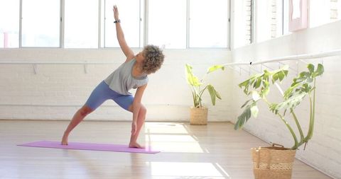 Woman Practicing Yoga in Sunlit Studio