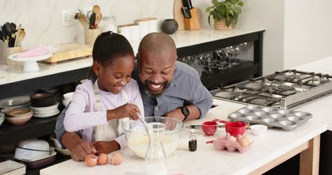 Father and Daughter Baking Together in Home Kitchen