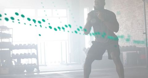 Athlete swinging battle ropes in bright industrial gym during intense functional training
