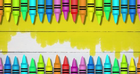 Colorful crayons arranged against vibrant yellow background