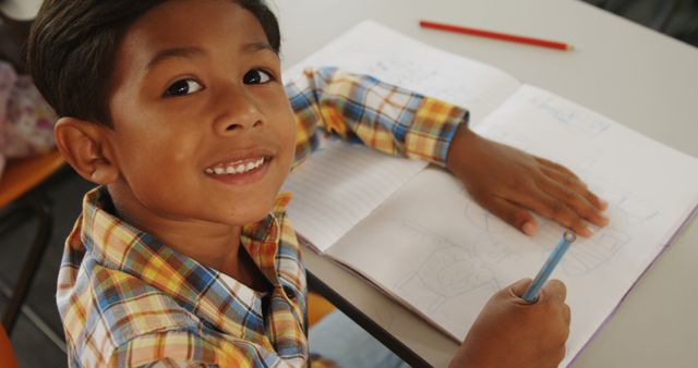 Smiling Boy Drawing and Writing in Notebook - Download Free Stock Images Pikwizard.com